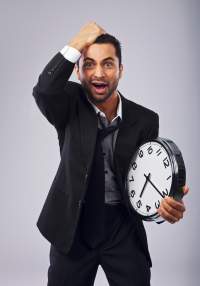 frustrated-businessman-holding-a-clock_HT7SxqU4Fe